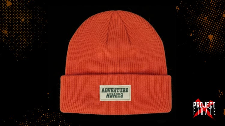 Orange beanie with Adventure Awaits patch symbolising professional growth and deliberate exploration